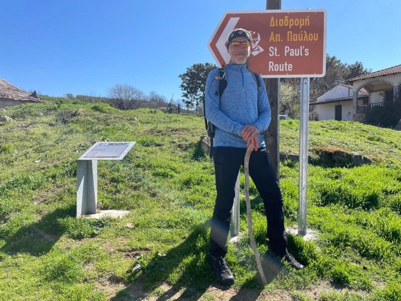 Torsten von Eschiakos mit Rucksack und Wanderstock vor einem Wegweiser der St. Paul Route
